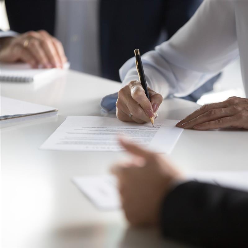 man holding a pen and signing the agreement