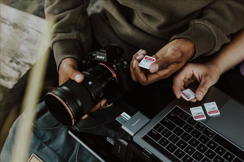 Man Holding Camera and SD Cards