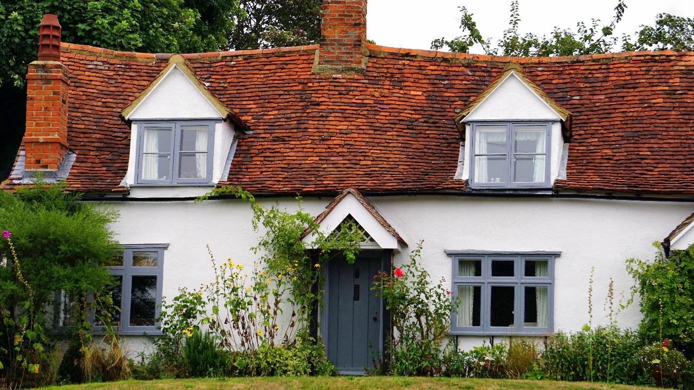 A large brick building with grass in front of a house
Description automatically generated